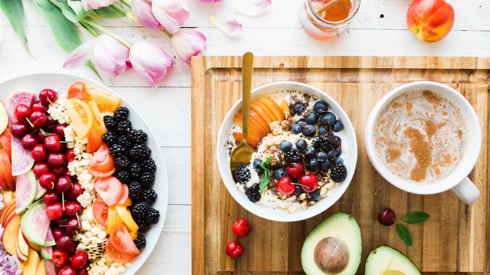 Plain yogurt, kefir, milk, cheese, berries and nuts beside an unsweetened fortified plant beverage on a bright table.