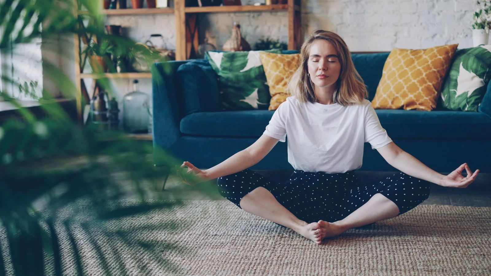 Adult seated calmly in a living room practicing slow mindful breathing.