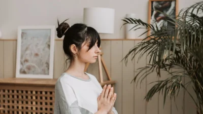 Adult practicing comfortable mindfulness meditation at home with calm breathing.