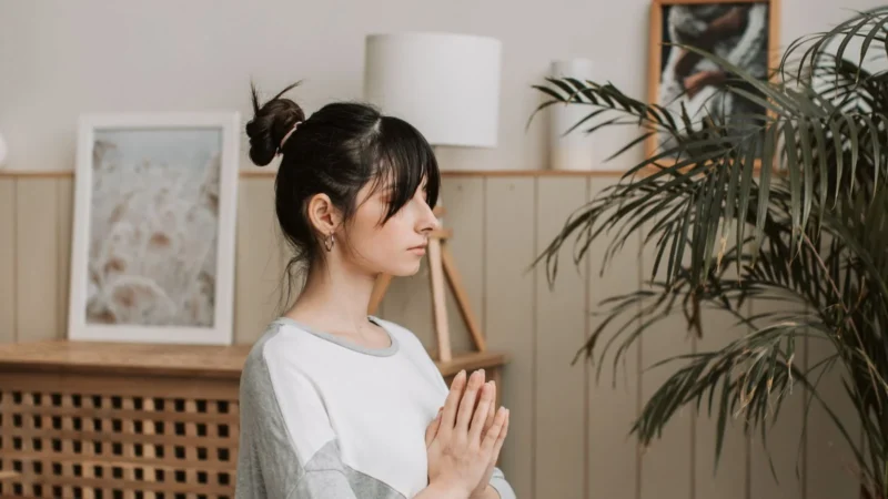 Adult practicing comfortable mindfulness meditation at home with calm breathing.