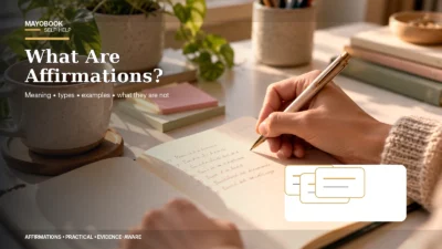 Person writing a realistic positive affirmation in a notebook at a desk